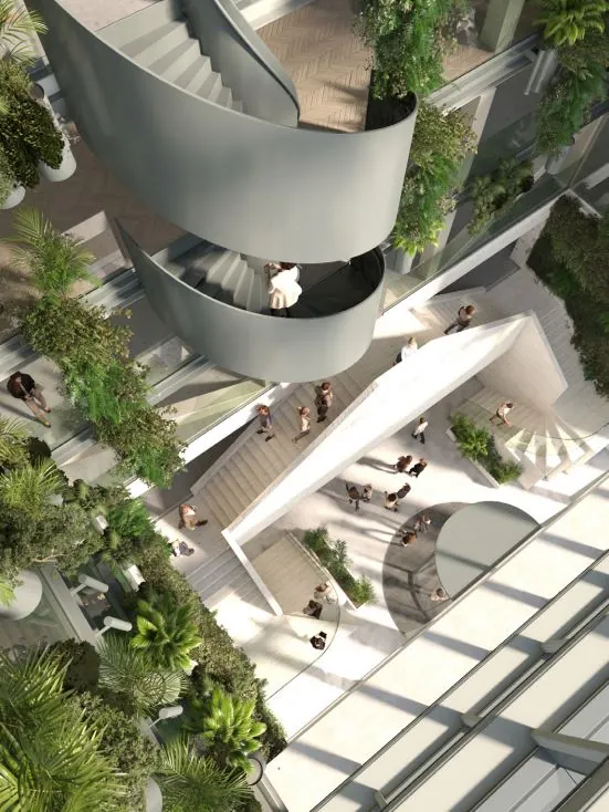 Een modern atrium aan de Marten Meesweg met een spiraalvormige trap, veel groen en mensen in een open, lichte ruimte.